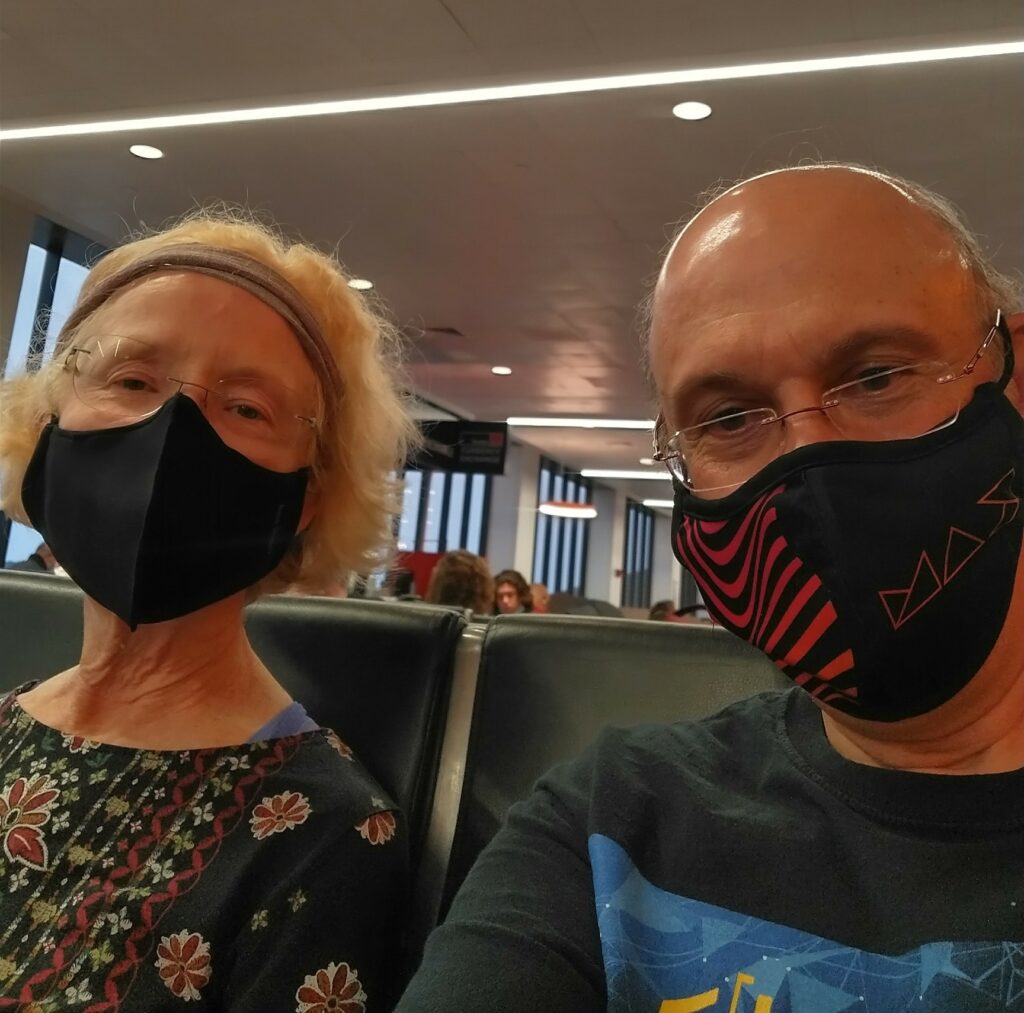 Pam and David, with masks, waiting for our flight at the airport in Boston